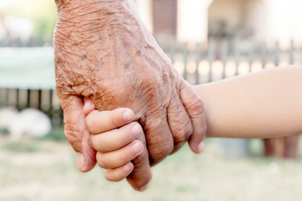 Senior and a child holding hands, a close up shot