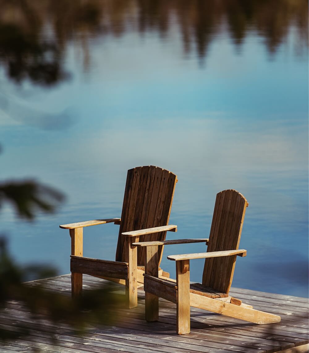 Two wooden chairs on a pier